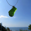 Grosser Anhänger aus grünem Seeglas in einer messingfarbenen Spirale