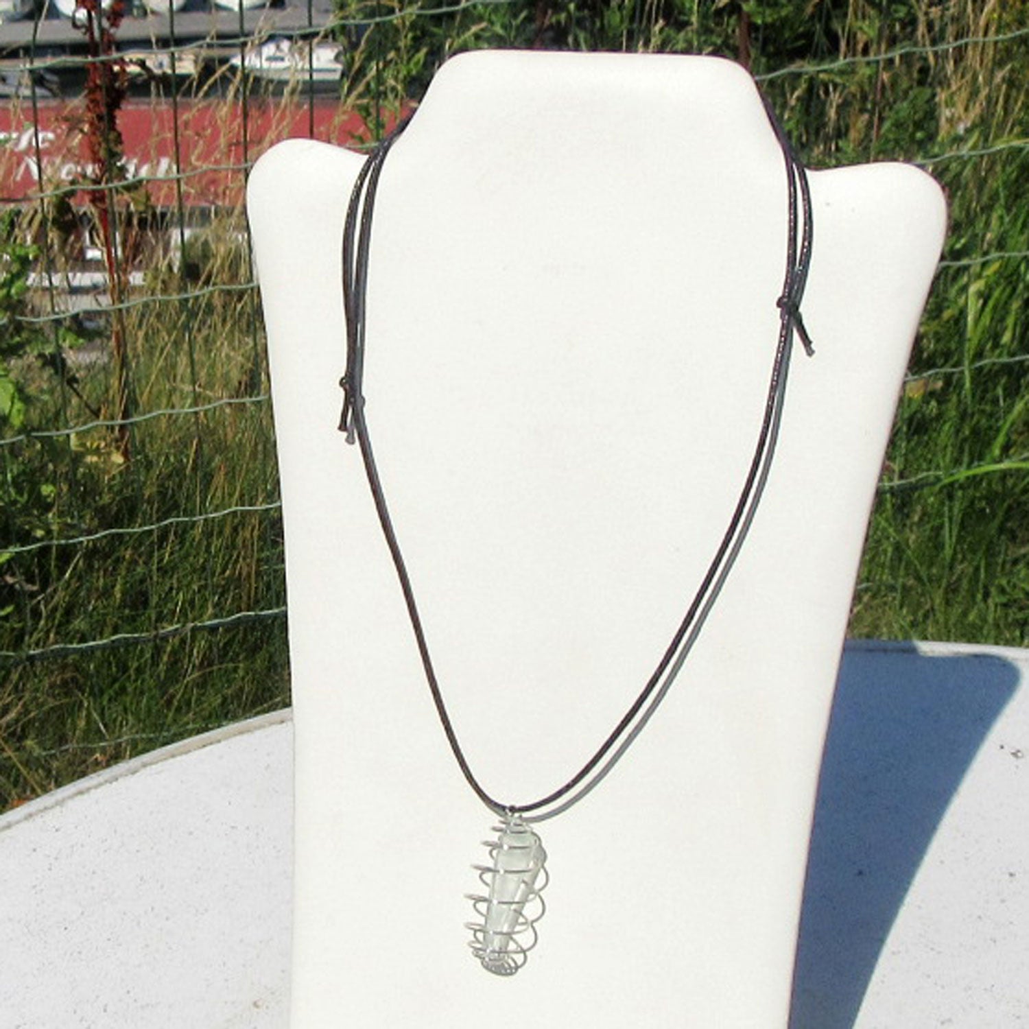 Anhänger mit weisslich/transparenten Seeglas in einer Spirale am Baumwollband