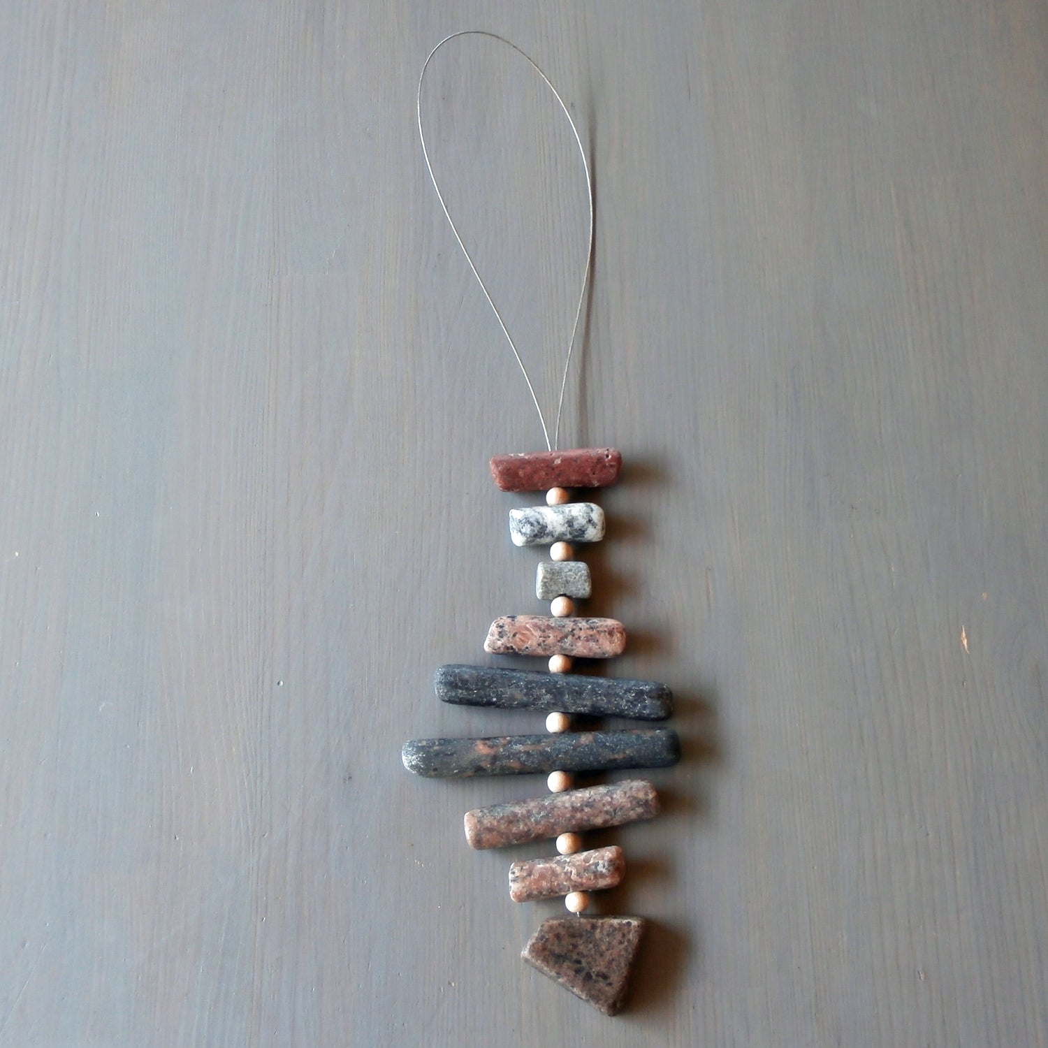 Rustikaler Topfuntersetzer aus Steinen von der Rügener Küste in Fischform