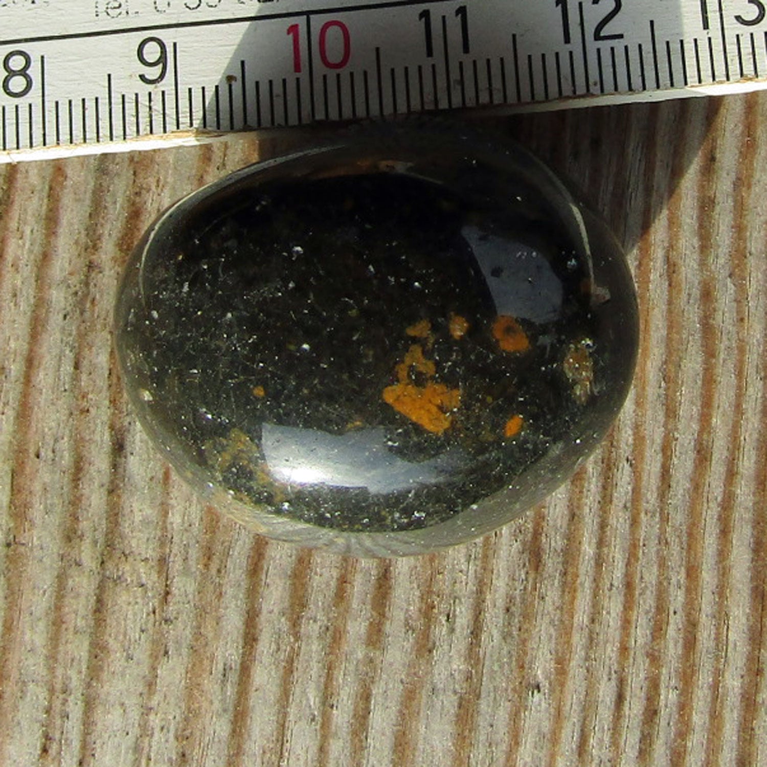 Wunderschöner, hochglanzpolierter Wallstein von der Rügener Küste – rund mit dunkler Farbe und braunen Akzenten