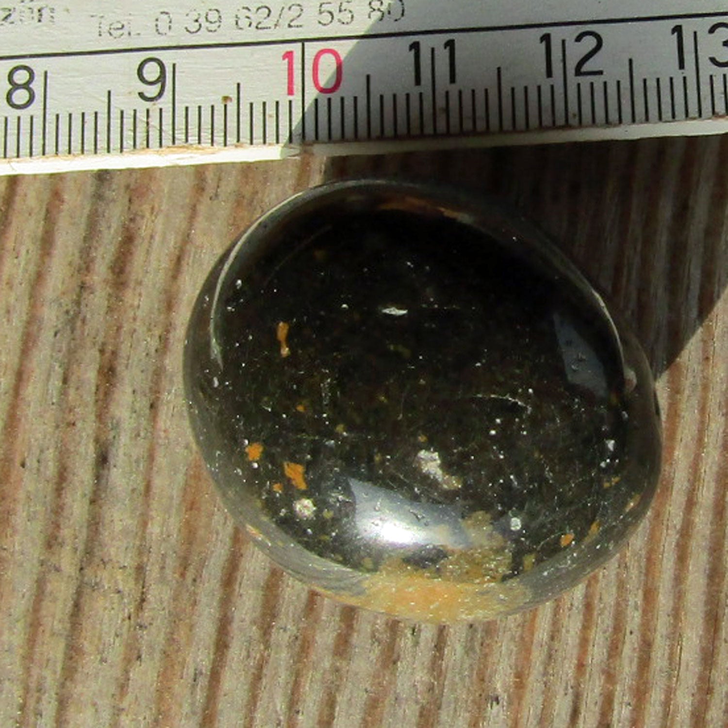 Wunderschöner, hochglanzpolierter Wallstein von der Rügener Küste – rund mit dunkler Farbe und braunen Akzenten