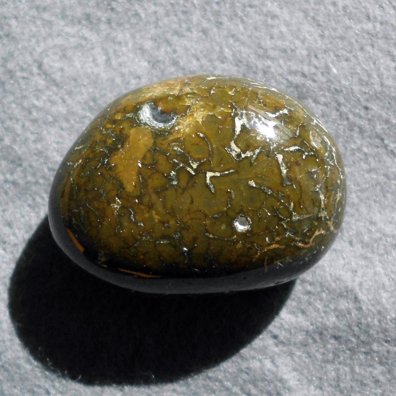 Ovaler, hochglanzpolierter Wallstein von der Rügener Küste – mit warmen Naturfarben