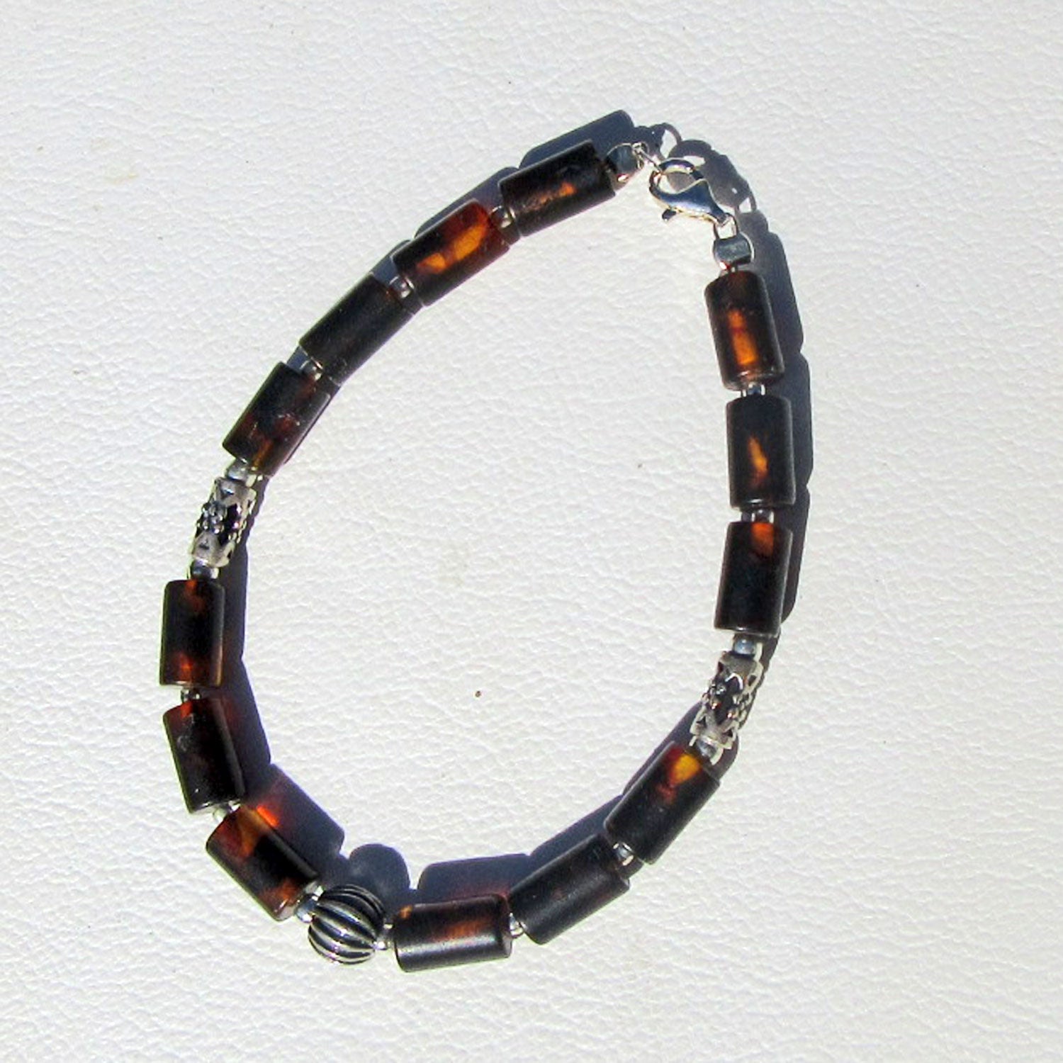 Edles Armband aus dunklen, unpolierten Bernsteinzylindern und Silberperlen