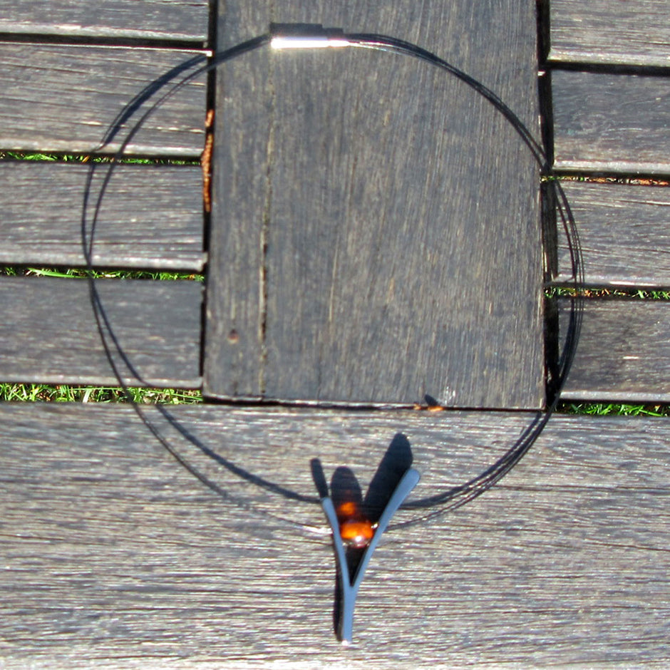 Edles Ypsilon aus versilbertem Draht mit Bernsteinperle