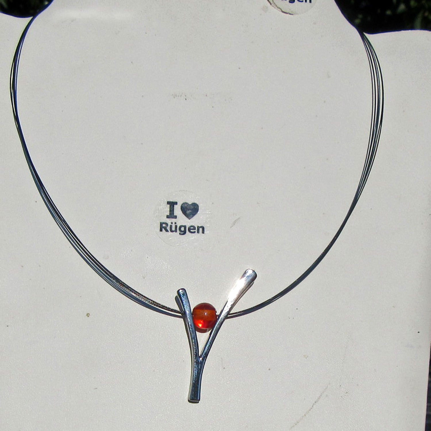 Edles Ypsilon aus versilbertem Draht mit Bernsteinperle